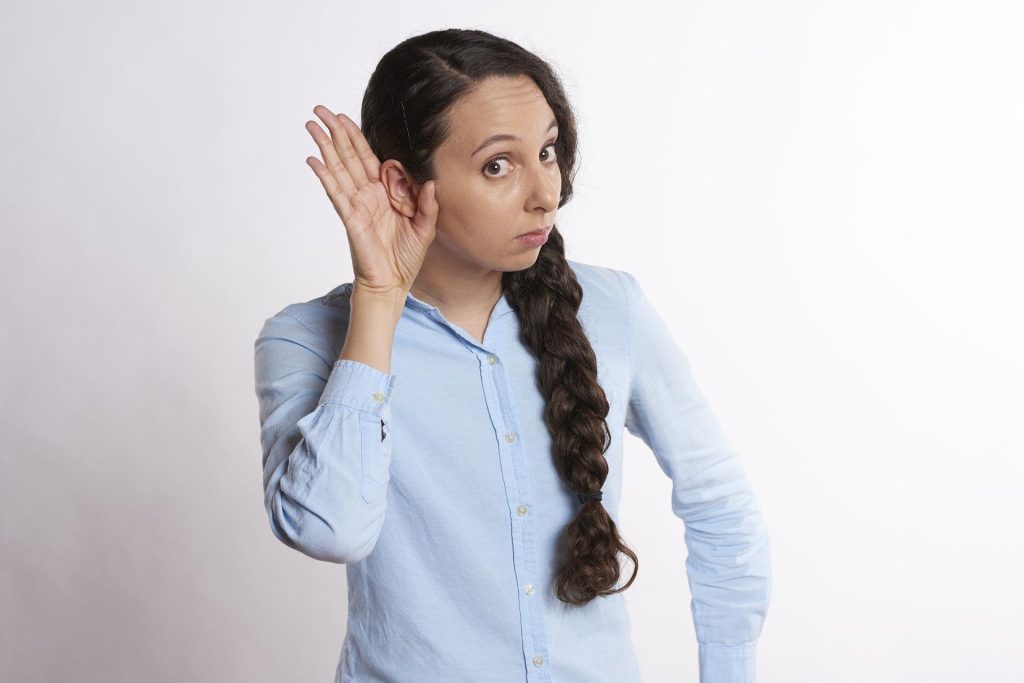 Frau fasst sich ans Ohr - Schwerhörigkeit. Im Artikel: Besser hören gegen Demenz?