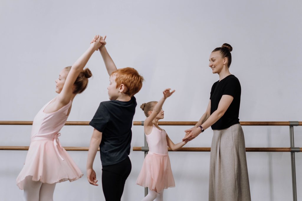 Drei Kinder mit Lehrerin im Ballett Unterricht. Im Artikel: Tanzen ist mehr als „hopsen“