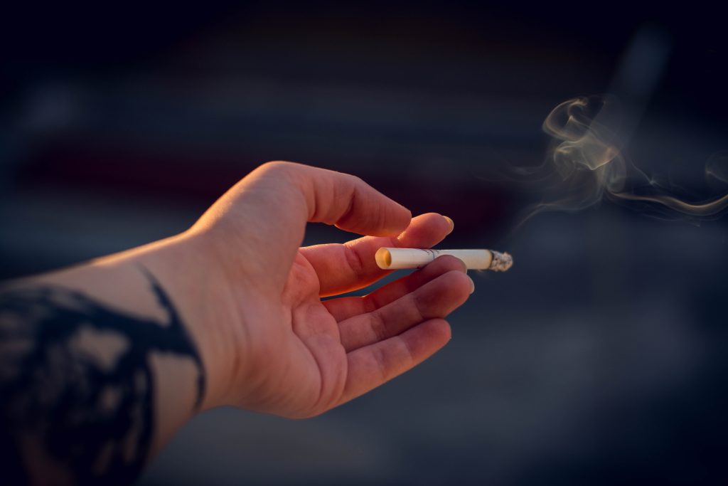 Hand mit qualmender Zigarette. im Artikel: Wie Entspannung gegen Sucht hilft
