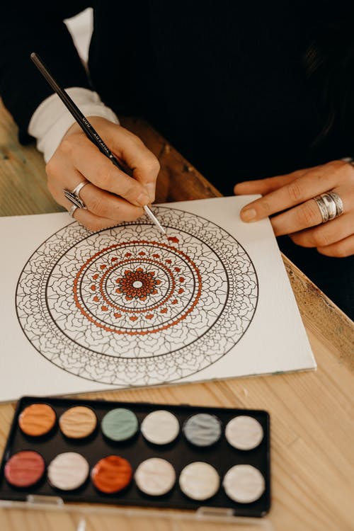 Person malt Mandala aus. In Artikel: Warum Malen hilft, Stress abzubauen