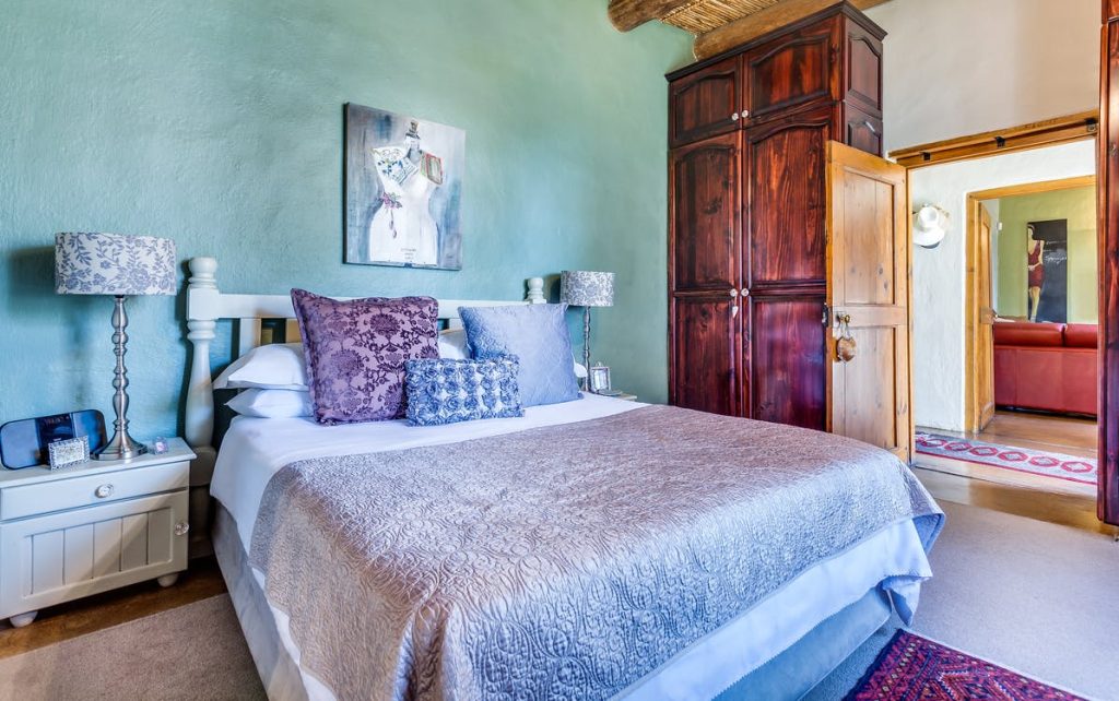 Schlafzimmer mit Bett und grüner Wand. Im Artikel: Farbe bringt Qualität ins Bett
