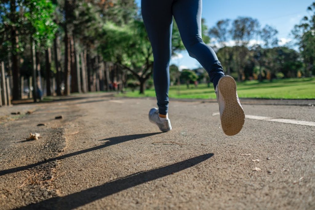 Beine beim Joggen auf Asphalt. Im Artikel: Laufen auf Waldboden oder Asphalt?